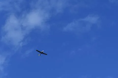 Small white cessna single propeller plane flying in a clear blue sky Stock Photos
