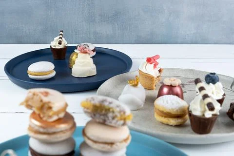 Small white chocolate cake next to assorted sweets. In the blurred foreground Stock Photos