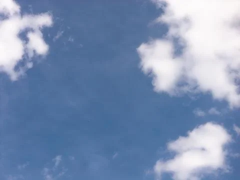 Small White Clouds Framing a Deep Blue Sky Opening Stock Photos