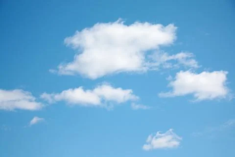 Small white clouds on light blue clear sky at sunny summer day Stock Photos