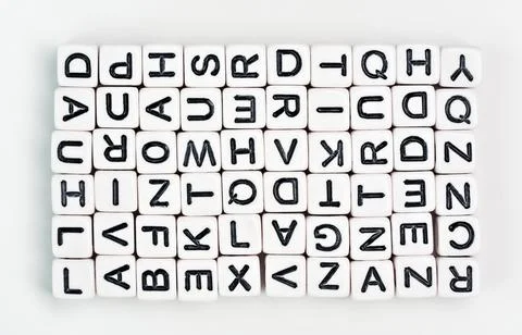 Small white cube beads with various letters arranged in rectangle, view from  写真素材