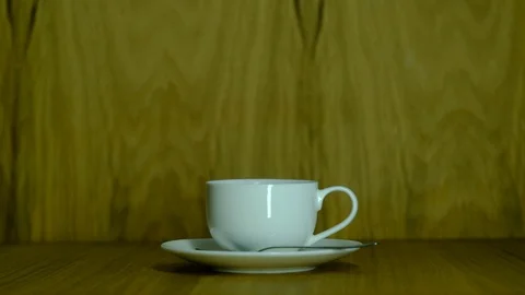 Small white cup with coffee on a saucer Stock Footage 129768036