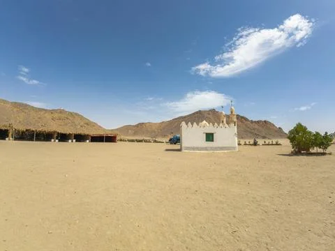 Small White Desert Mosque Surrounded by Rocky Mountains Under Blue Sky Stock Photos