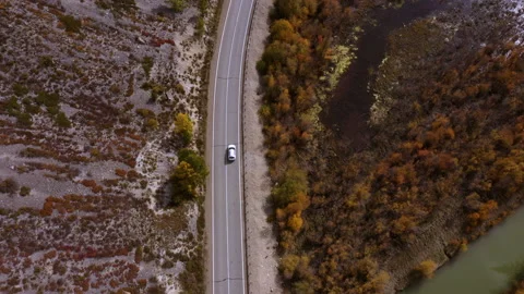 Small white family hatchback moving through picturesque landscapecar driving Stock Footage 157441501