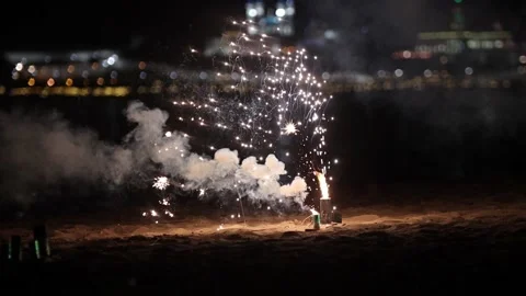 Small white firework burning and exploding on the beach Stock Footage 133026294