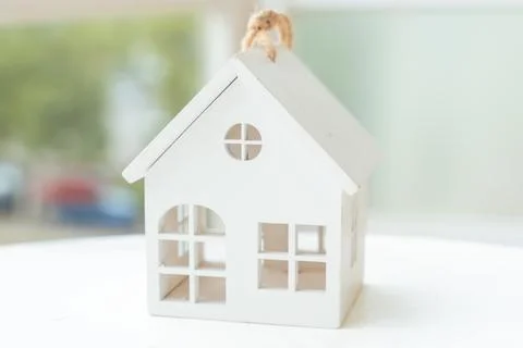 Small white house model on table with soft natural light background. Stock Photos