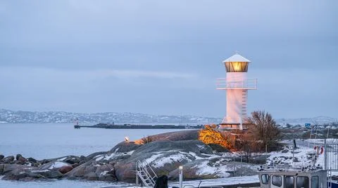 Small white lighthouse by the harbour. Stock Photos