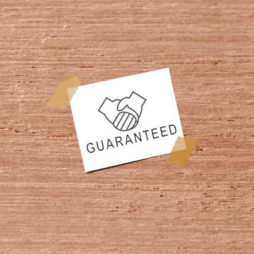 A small white note featuring a handshake icon and the word "GUARANTEED" tap.. Stock Photos