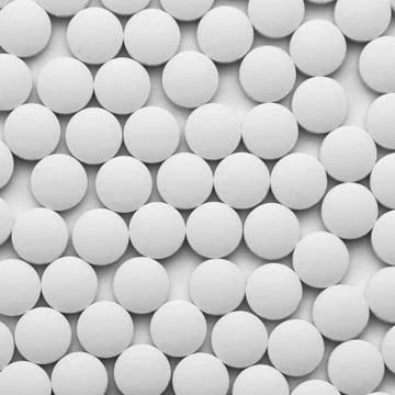 Small white pills on a white background close-up. Stock Photos