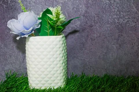 Small White Pot with Artificial Flowers with Cement Texture Background Stock Photos