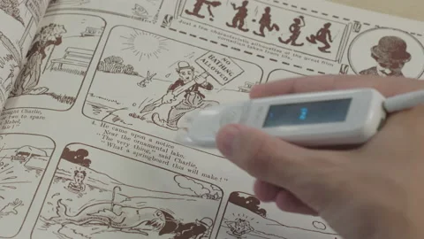 Small white reading aid tool helping read comic book handicapped aiding Stock Footage 220838961