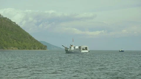 A small white ship floats in Lake Baikal near its coast in summer Stock Footage 81042479