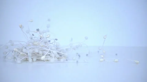 Small white things for craft making falling on the table in slow motion. Winter Stock Footage 95503125