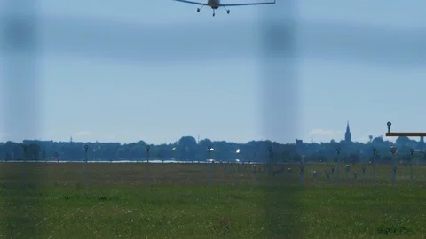 Small white training airplane with propeller engines landing at airport in Stock Footage 113033031