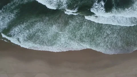 Small white waves breaking on a sandy beach with dark green sea water Stock Footage 169407711