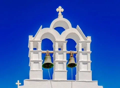 Small whitewashed belfry against clear blue sky. Orthodox church in Amorgos Stock Photos