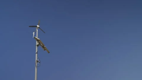 Small Wind Turbine and Solar Panel Generating Renewable Energy Stock Footage 338363517