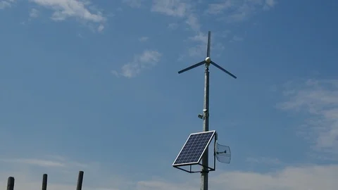 Small wind turbine with solar panel, blue sky background Stock Footage 94190700