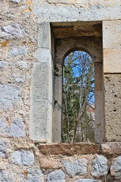 A small window in a castle made of stone Stock Photos
