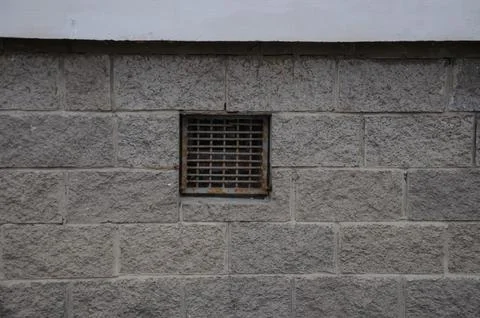 A small window with a cellar bar. ventilation window in the wall of the house Stock Photos