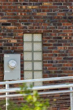 Small window in old brick with modern rails 스톡 사진