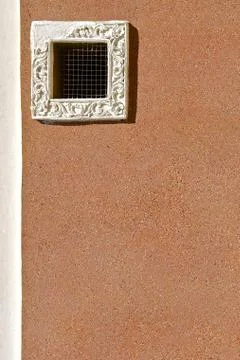 Small window on a sandy pebbledashed wall. Stock Photos
