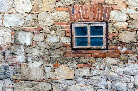 Small window on a stone wall Stock Photos