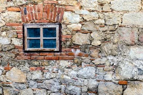 Small window on a stone wall Stock Photos
