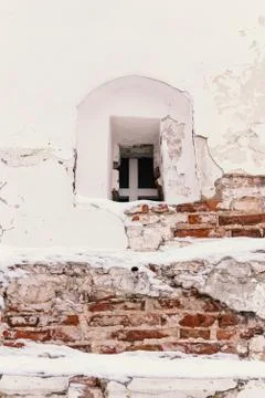 Small window in the wall of a crumbling white church Stock Photos