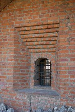 A small window in the wall of an old monastery. Stock Photos