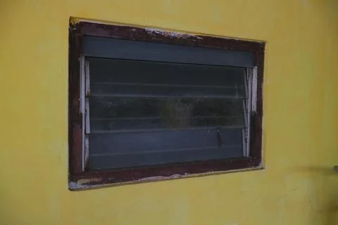 The small window on the yellow wall Stock Photos