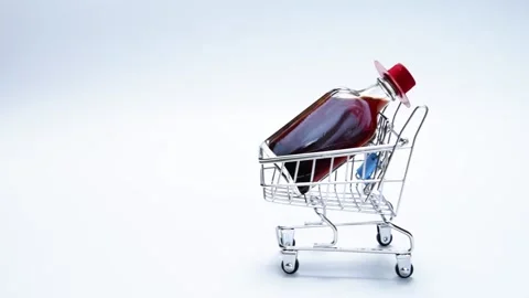 Small wine bottle with red hat in mini shopping cart Stock Footage 163904513