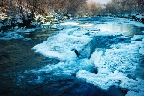 Small winter frozen river with cascades Stock Photos