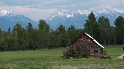 Small wood cabin with mountain backdrop Stock Footage 67610425