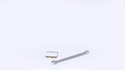 Small wrench and computer chip isolated on white background. Repairs concept. Stock Photos