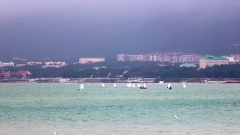 Small yachts are sailing fast on a green stormy sea against a background of blac Stock Footage 256461111