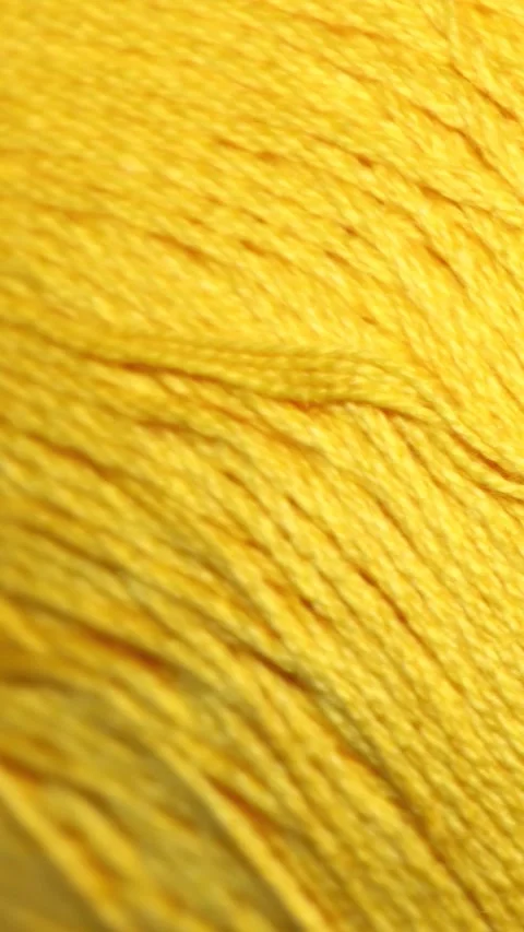 A small yellow ball of yarn on a clean white surface, ready for knitting or.. Video stock 344158845