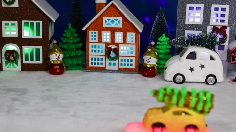 A small yellow car moves slowly against the backdrop of a Christmas village Stock Footage 308569715