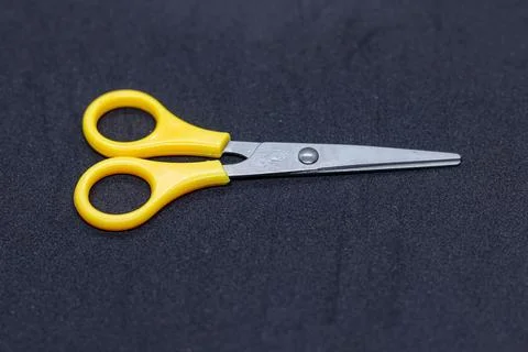 Small Yellow Handled Scissors with Stainless Steel Blades on Black Surface Stock Photos