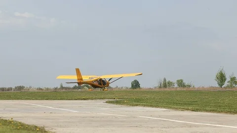 Small yellow private airplane with propeller landed on runway at airfield. Video stock 120870014