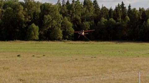 Small yellow private plane flies up to runway of local airfield and lands on Stock Footage 237118636
