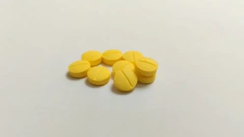 Small yellow tablet medicine on a white background 스톡 동영상 314930053
