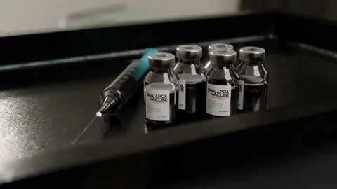 Smallpox monkeypox vaccine ampoule, sided by a blue transparent syringe Stock Footage 201297998