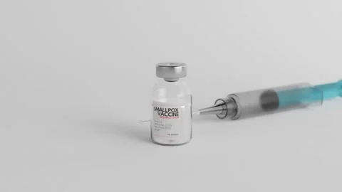 Smallpox Monkeypox vaccine ampoule sided by a blue syringe on a white studio. Stock Footage 201331432