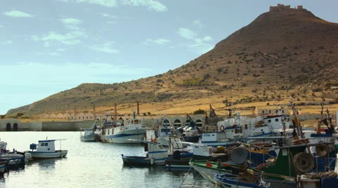 Smalltown dock surrounded by a hill with an abandoned norman castle on top Stock Footage 52055935