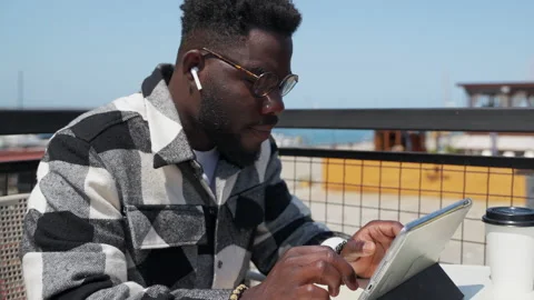 Smart african american man is using tablet with free wifi connection in city Stock Footage 231901453