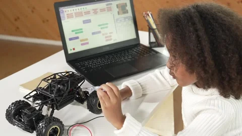 Smart african girl using screwdriver to repair or build a car model. Erudition. Stock Footage 262092972