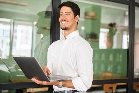 Smart and intelligent developer guy is working with laptop standing in Foto stock