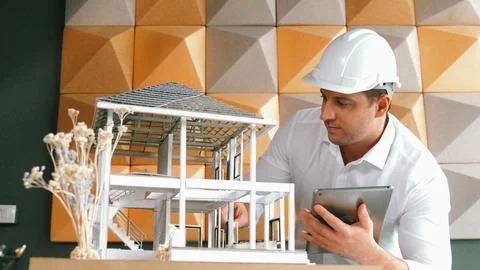 Smart architect engineer using tablet analysis house construction. Manipulator. Stock Photos