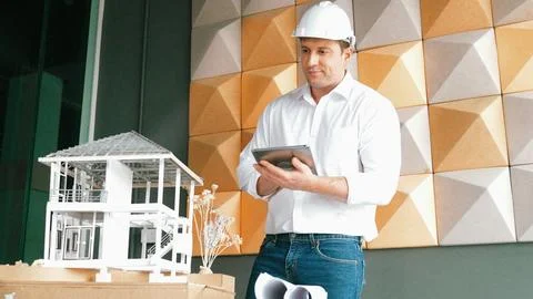 Smart architect engineer using tablet analysis house construction. Manipulator. Stock Photos